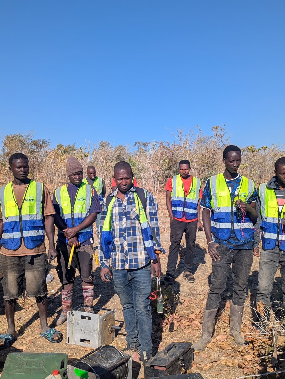 Altoro team members together in the field wearing high-visibility vests